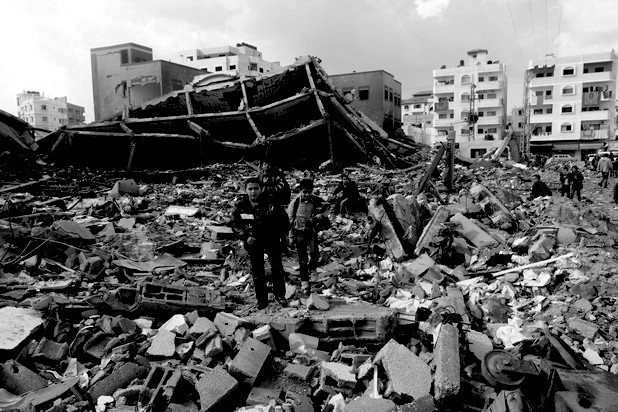 Palestinians school girls walk on the rubble of a building destroyed during earlier Israeli bombardment, as they make their way to their nearby school in Gaza City